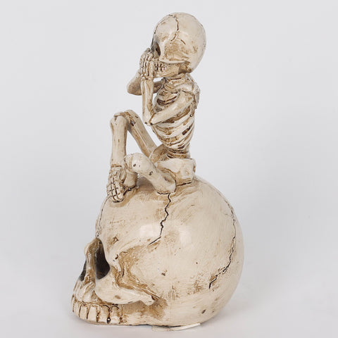 3.0*3.5*6.75'' Resin Covering Mouth Skeleton Sitting On Skull Décor W/Lite