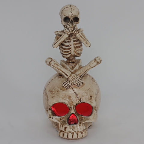 3.0*3.5*6.75'' Resin Covering Mouth Skeleton Sitting On Skull Décor W/Lite