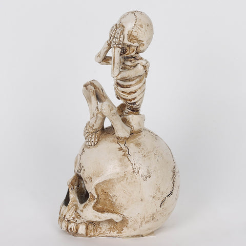 3.0*3.5*6.75'' Resin Covering Eyes Skeleton Sitting On Skull Décor W/Lite
