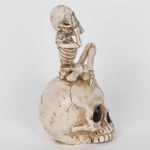 3.0*3.5*6.75'' Resin Covering Eyes Skeleton Sitting On Skull Décor W/Lite