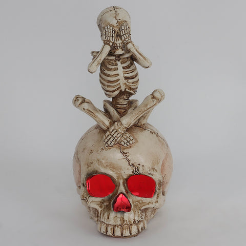 3.0*3.5*6.75'' Resin Covering Eyes Skeleton Sitting On Skull Décor W/Lite
